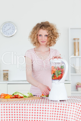 Good looking blonde woman using a mixer in the kitchen