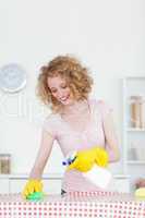 Gorgeous red-haired woman cleaning a cutting board in the kitche