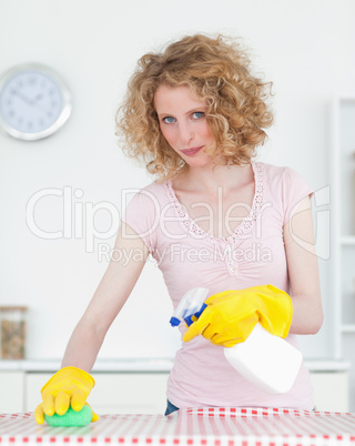 Pretty red-haired woman cleaning a cutting board in the kitchen