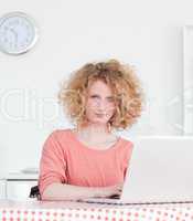 Gorgeous blonde woman relaxing with her laptop while sitting in