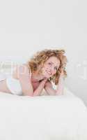 Lovely blonde woman relaxing while lying on her bed