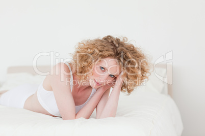 Attractive blonde woman relaxing while lying on her bed