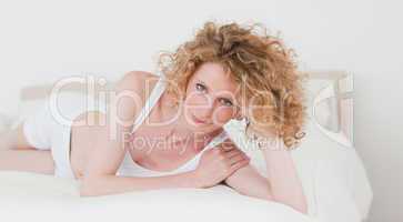 Cute blonde woman relaxing while lying on her bed