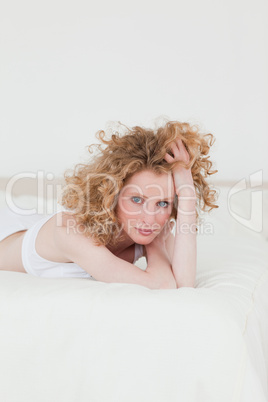 Pretty blonde woman relaxing while lying on her bed