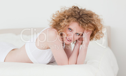 Gorgeous blonde woman relaxing while lying on her bed