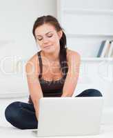 Cute dark-haired woman using her laptop