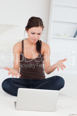 Angry dark-haired woman using her laptop