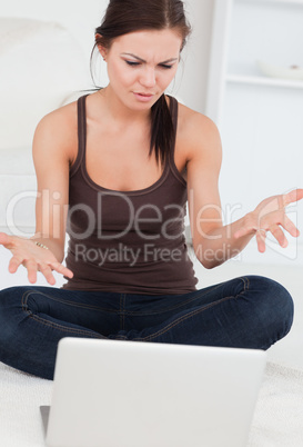 Close up of an angry dark-haired woman using her laptop