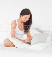 Brunette surfing on the internet with her laptop