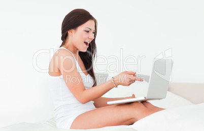 Laughing brunette with her laptop