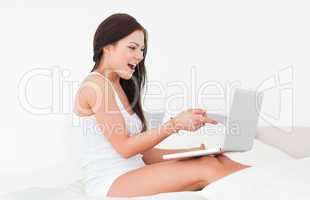 Laughing brunette with her laptop