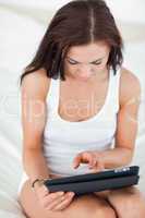 Portrait of a cute brunette using a tablet