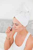 Portrait of a woman curling her eyelashes