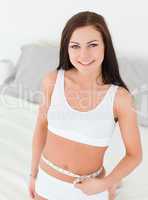 Beautiful woman measuring her belly