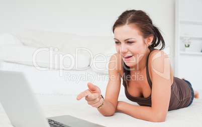 Cute woman pointing at the screen of her laptop