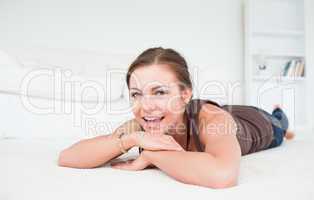 Smiling woman liying on a carpet