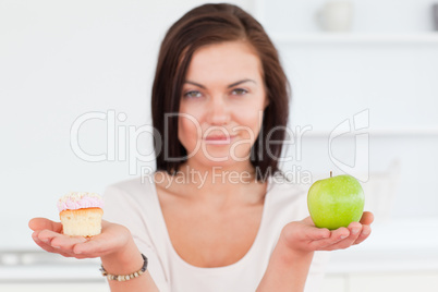 Charming brunette with an apple and a piece of cake