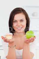Portrait of a cute brunette with an apple and a piece of cake