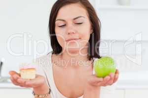 Close up of a cute brunette with an apple and a piece of cake