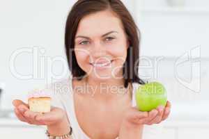 Close up of a cute woman with an apple and a piece of cake
