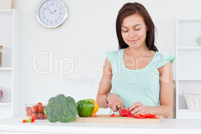 Cute woman slicing a pepper