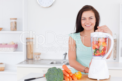 Charming woman using a blender