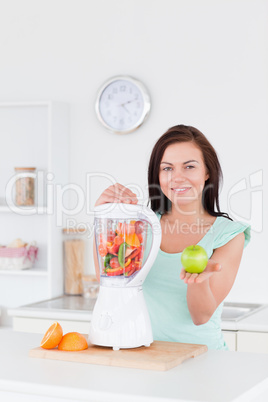 Cute woman with a blender and an apple