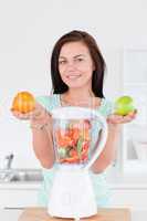 Happy woman with a blender and fruits