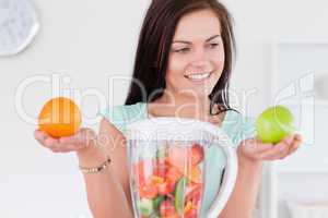 Charming woman with a blender and fruits