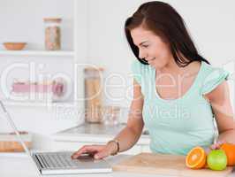 Young woman with a laptop and fruits