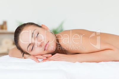 Woman lying on her belly closing her eyes