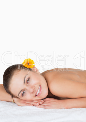 Portrait of a dark-haired woman with a flower on her ear