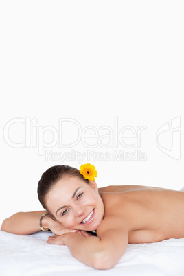 Portrait of a smiling brunette with a flower on her ear