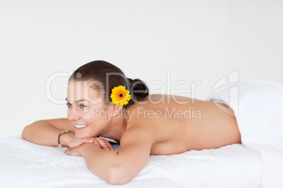Happy brunette with a gerbera on her ear
