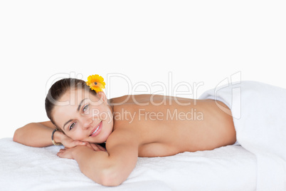 miling brunette with a gerbera on her ear