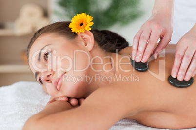 Close up of a cute woman enjoying a hot stone massage