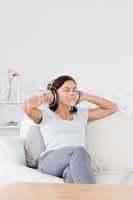 Delighted dark-haired woman listening to music