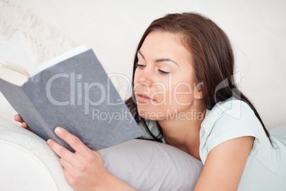 Close up of a woman on a sofa reading a book