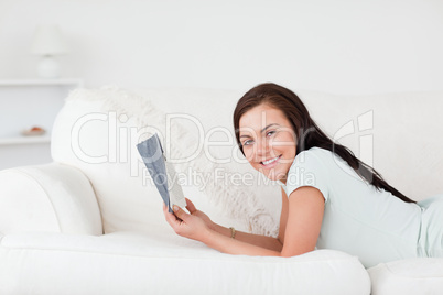 Relaxed woman on a sofa holding a book
