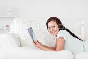 Relaxed woman on a sofa holding a book