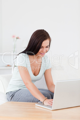 Cute young woman typing on her laptop