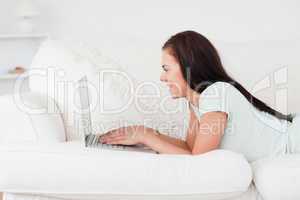 Cute woman on a sofa using a laptop