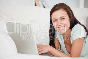 Close up of a brunette on a sofa using a laptop