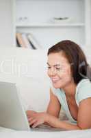 Portrait of a young woman on a sofa using a laptop