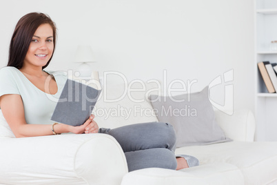 Sitting young brunette with a book