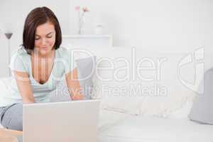 Young brunette typing on her laptop