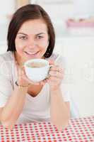 Cute dark-haired woman having a coffee