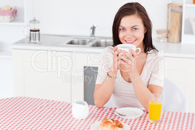 Charming brunette having her breakfast