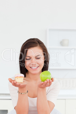 Portrait of a charming brunette with an apple and a piece of cak