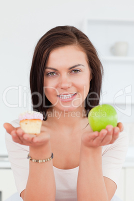 Portrait of a cute brunette with an apple and a piece of cake